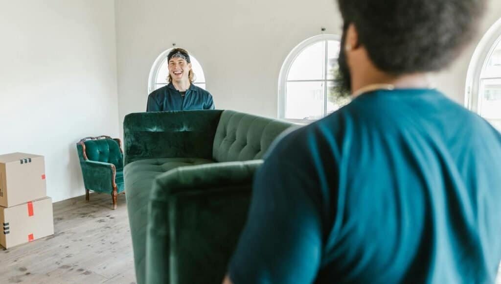 Moving business employees picking up couch together