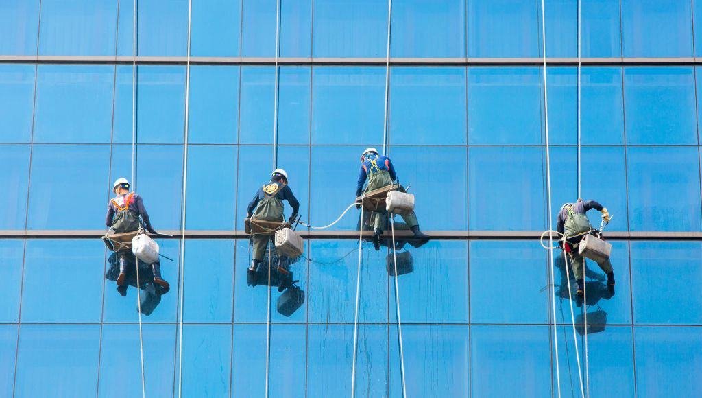 team of four cleaning windows on a high rise skyscraper